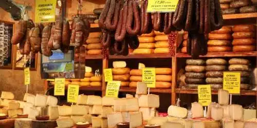 Étals de fromages artisanaux et charcuteries locales, illustrant la richesse gastronomique des marchés basques.